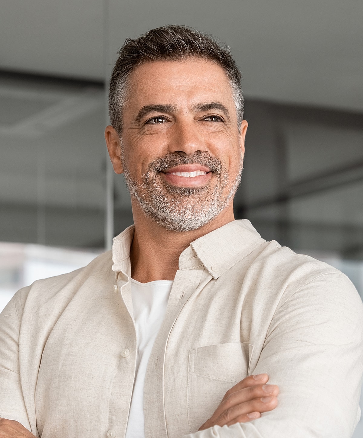 Smiling man wearing a light shirt indoors.