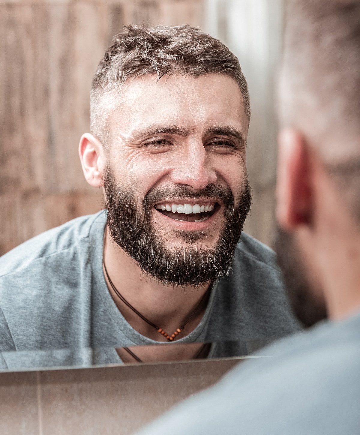 Man smiling in front of a mirror.
