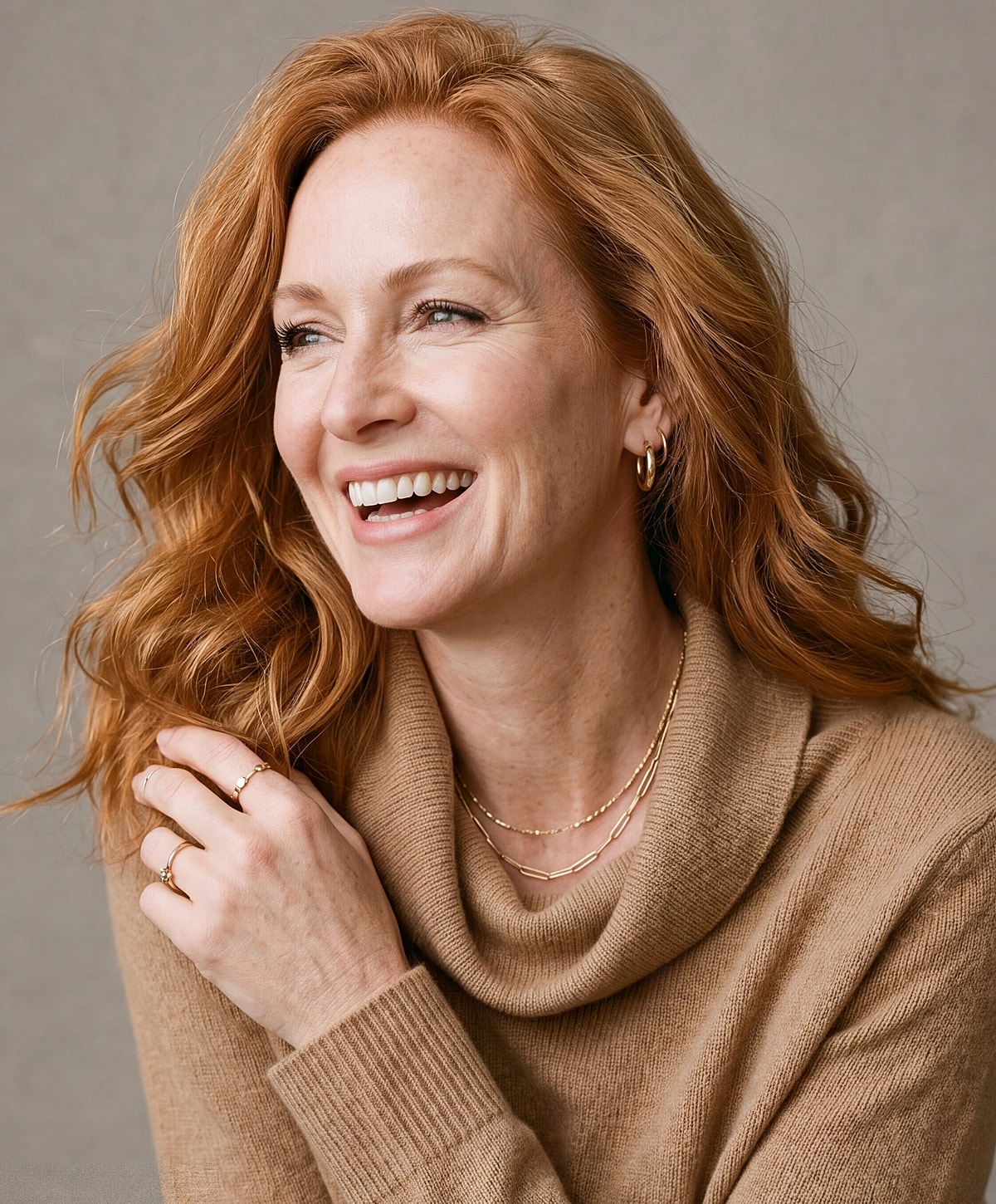 Woman smiling in cozy sweater, enjoying life.
