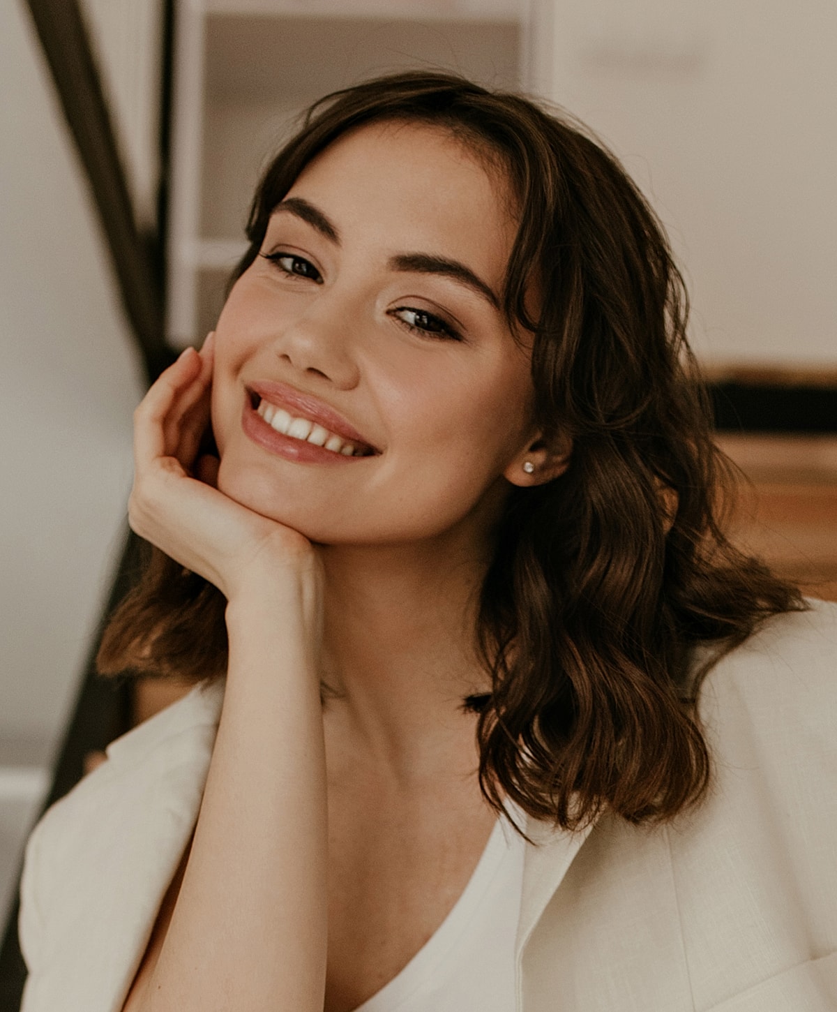 Smiling woman resting her chin on hand.