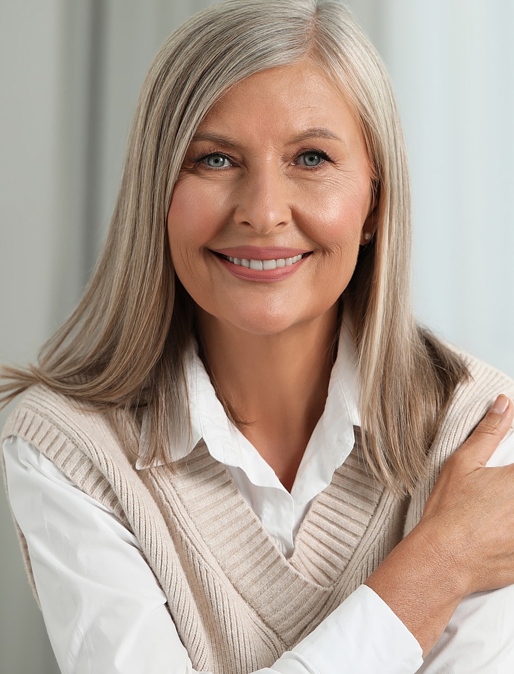 Smiling older woman in casual sweater vest.