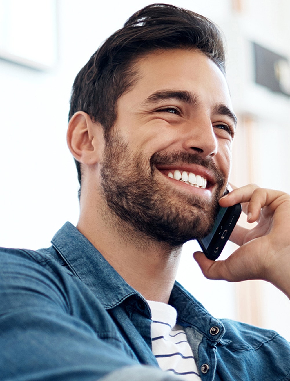 Smiling man talking on the phone.
