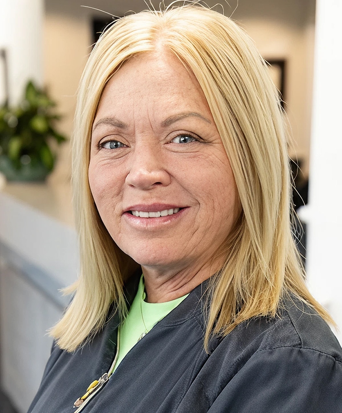 Smiling woman with blonde hair in workplace.