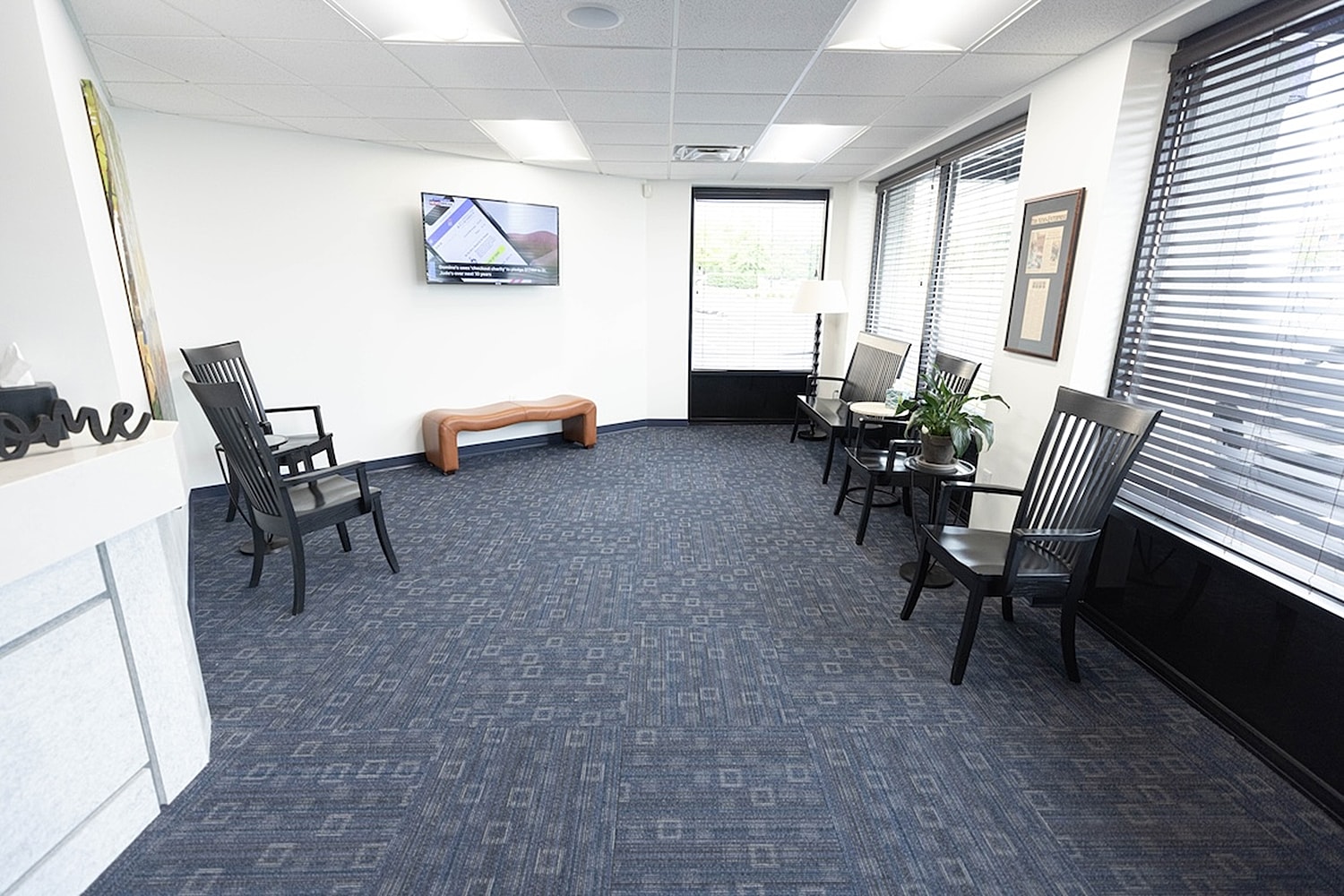Modern waiting room with chairs and television.