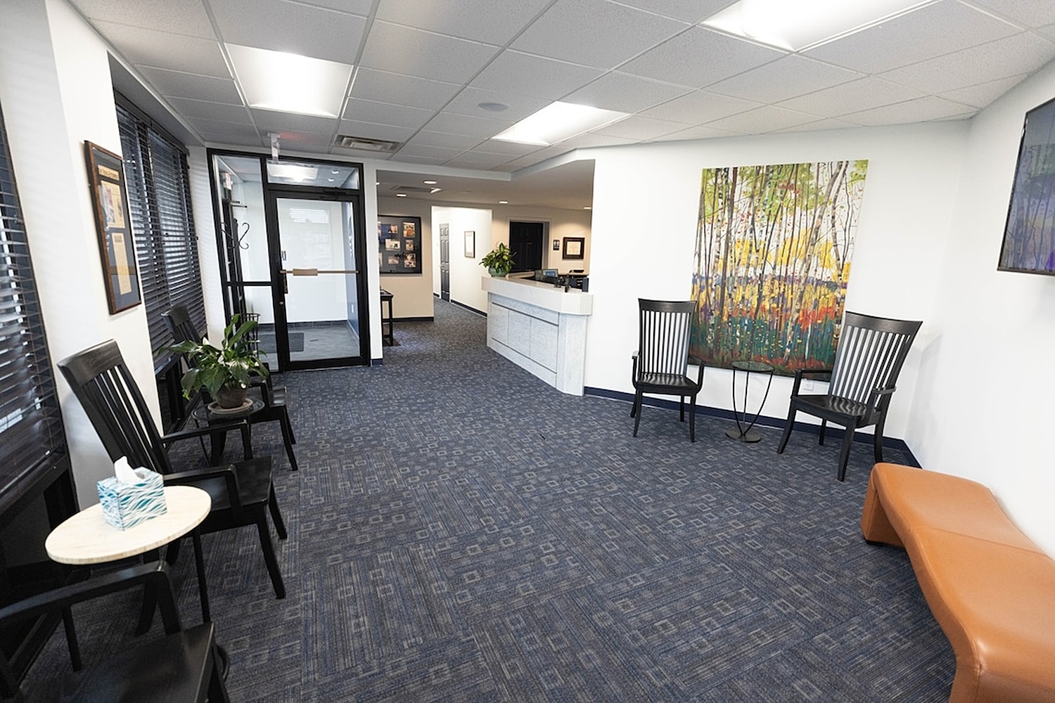 Modern waiting room with artwork and seating.