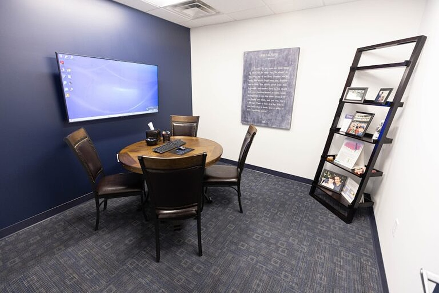 Modern meeting room with TV and bookshelf.