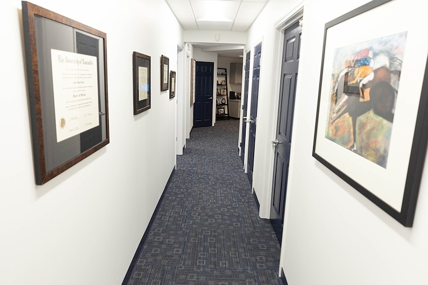 Office hallway with framed documents and artwork.