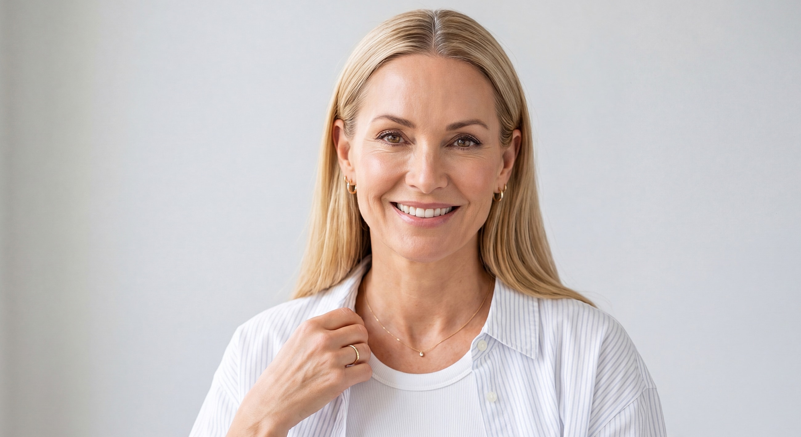 Smiling woman in casual attire with soft background