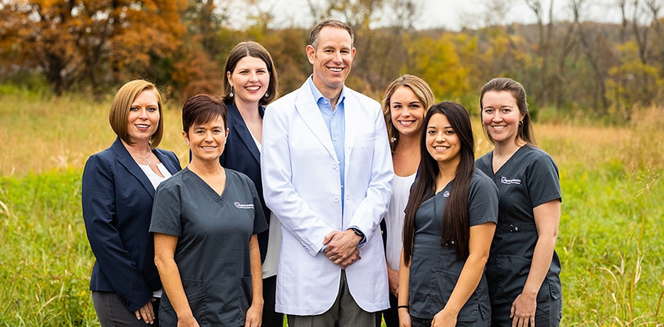 Medical team posed outdoors in professional attire.